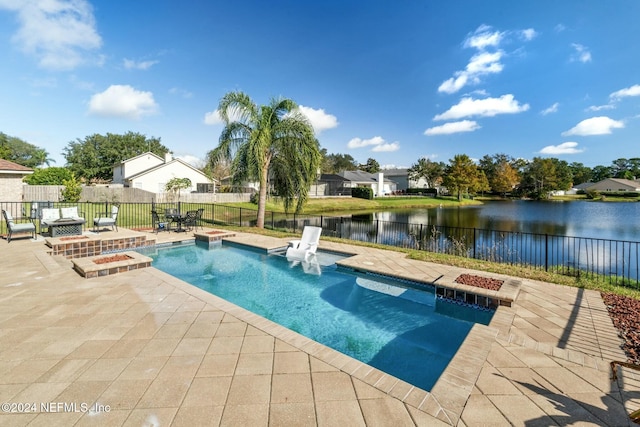 view of swimming pool with a water view and a patio