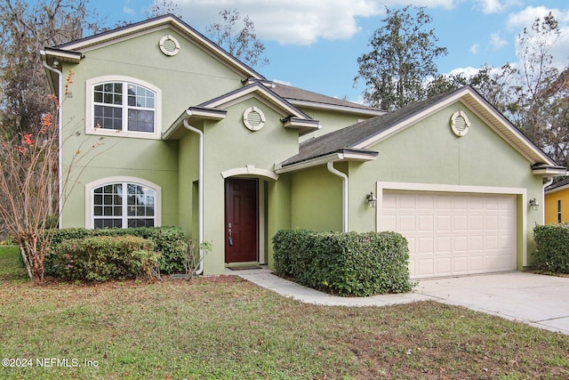 view of property featuring a garage and a front yard