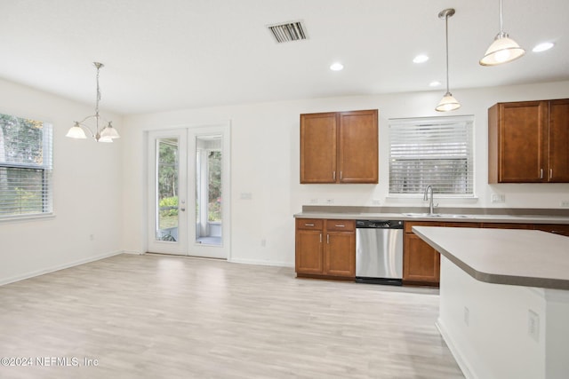 kitchen with decorative light fixtures, stainless steel dishwasher, and a wealth of natural light