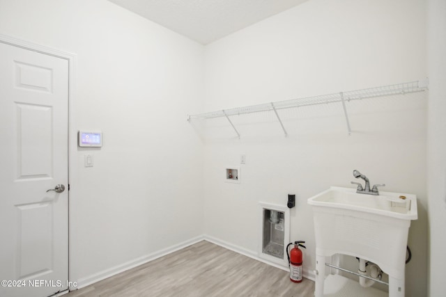 washroom featuring wood-type flooring, hookup for a washing machine, and sink