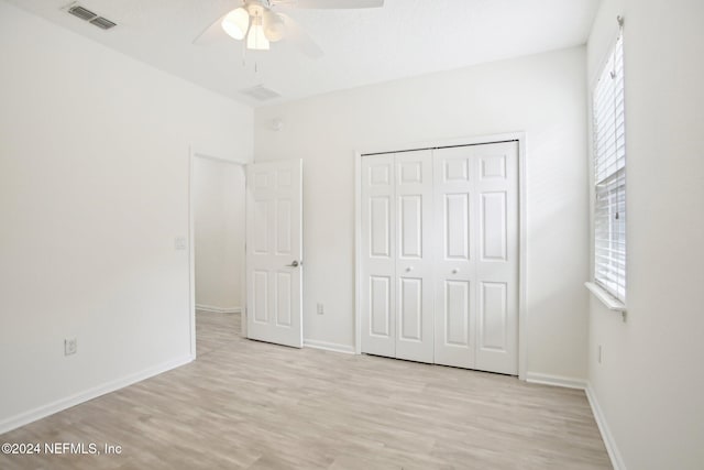 unfurnished bedroom with ceiling fan, light hardwood / wood-style flooring, and a closet