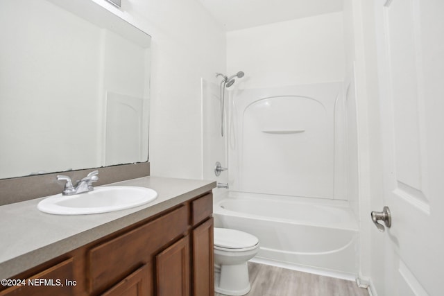 full bathroom with hardwood / wood-style floors, vanity, bathtub / shower combination, and toilet