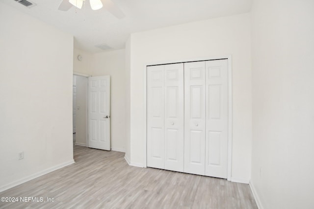 unfurnished bedroom featuring ceiling fan, light wood-type flooring, and a closet