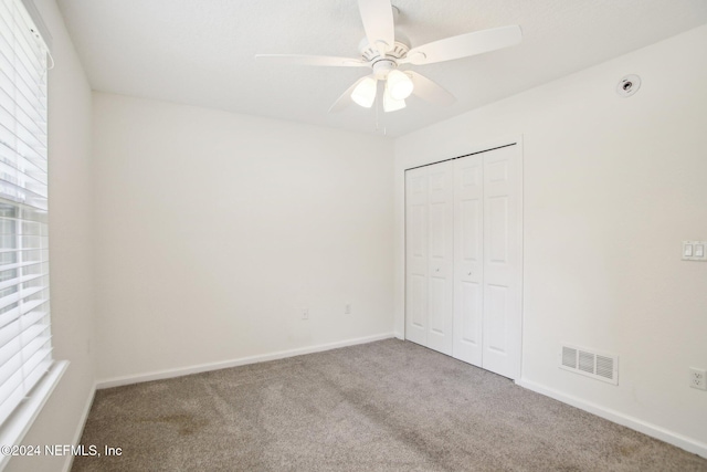 unfurnished bedroom with carpet floors, a closet, and ceiling fan