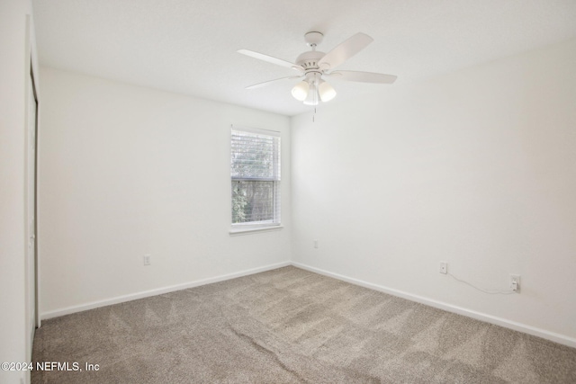 carpeted empty room featuring ceiling fan