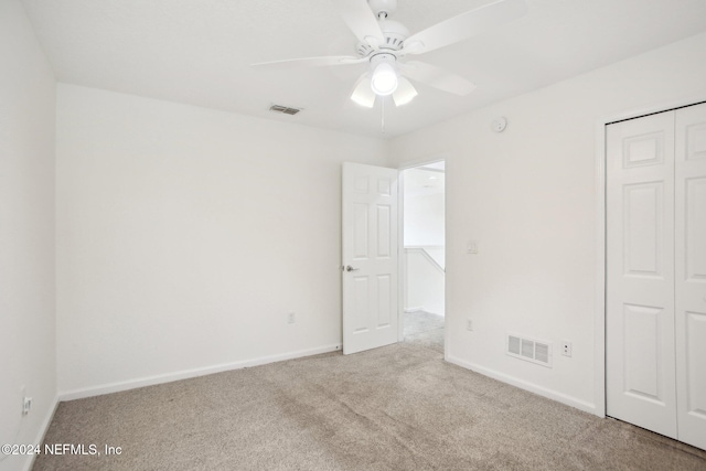 unfurnished bedroom with light carpet, a closet, and ceiling fan