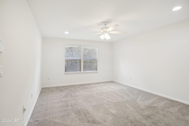 unfurnished room featuring light carpet and ceiling fan