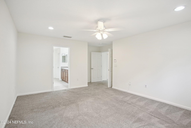 empty room featuring ceiling fan and light colored carpet