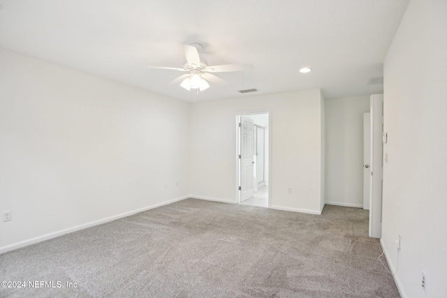 carpeted spare room with ceiling fan