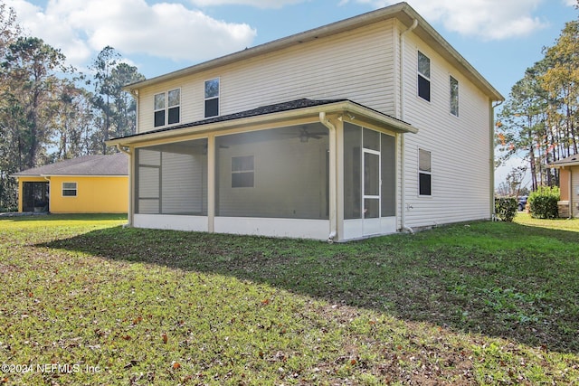 back of property with a sunroom and a yard