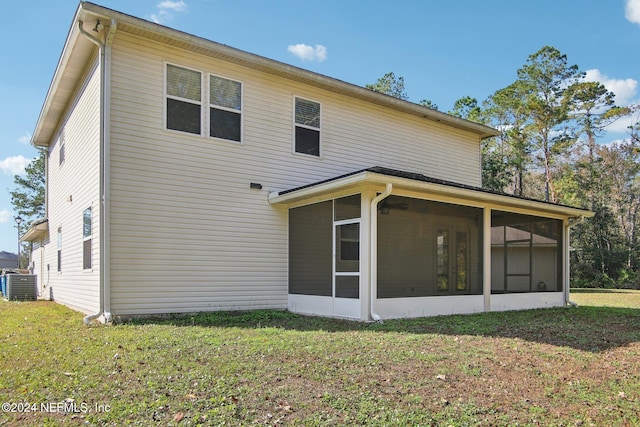 rear view of property featuring a sunroom, a yard, and central AC