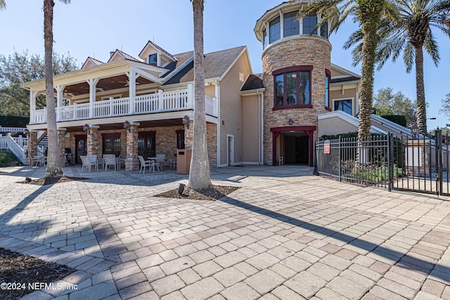 view of front of house featuring a balcony and a patio