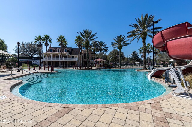 view of pool featuring a patio area and a water slide