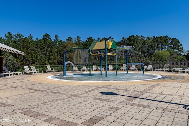 community play area featuring a patio and fence