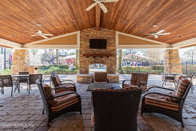 view of patio with an outdoor living space with a fireplace and ceiling fan