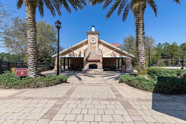 view of property with decorative driveway and fence