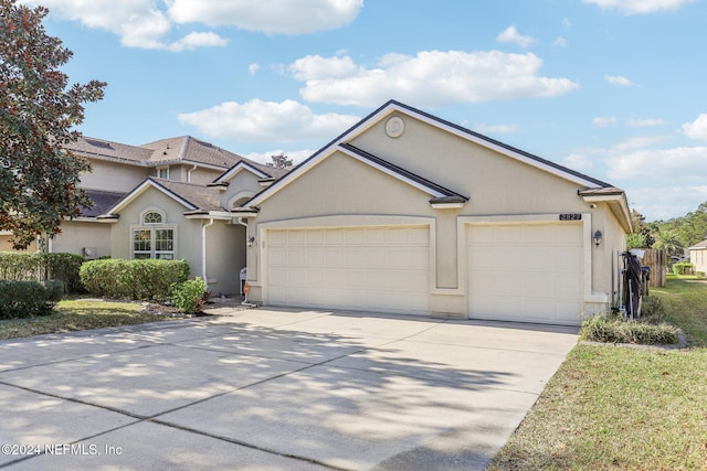 view of front of home featuring concrete driveway, an attached garage, and stucco siding