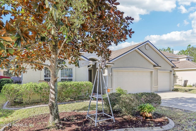 view of front of home with stucco siding, a garage, and concrete driveway