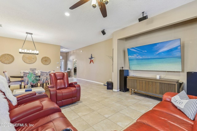 living room with a textured ceiling, light tile patterned flooring, and ceiling fan with notable chandelier