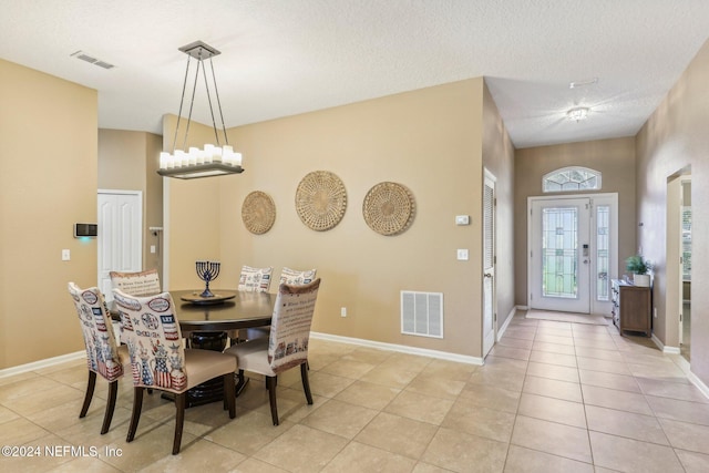 dining space with a textured ceiling and light tile patterned flooring