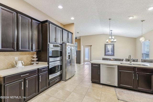 kitchen featuring a sink, appliances with stainless steel finishes, light tile patterned flooring, light countertops, and dark brown cabinets