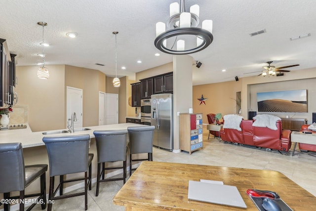 interior space with ceiling fan, sink, light tile patterned floors, and a textured ceiling