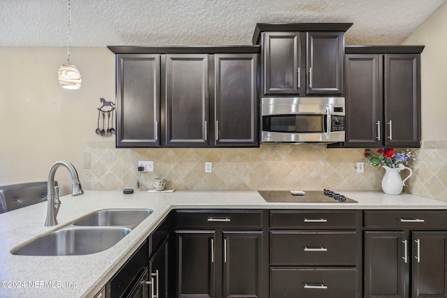 kitchen featuring dark brown cabinetry, sink, decorative light fixtures, decorative backsplash, and black electric stovetop