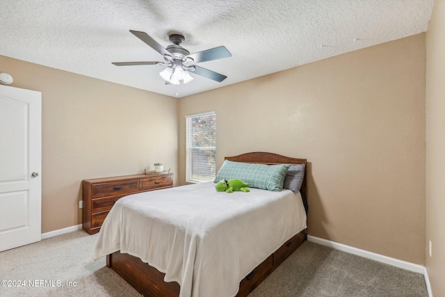 bedroom featuring ceiling fan, carpet floors, and a textured ceiling