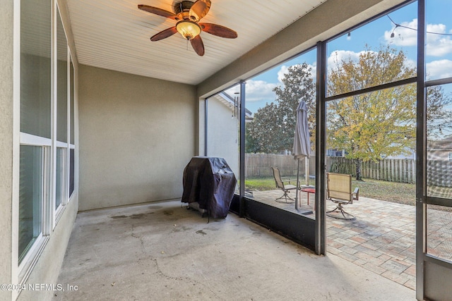 unfurnished sunroom featuring ceiling fan