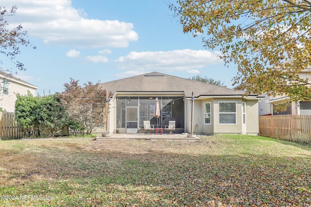 back of house with a sunroom and a lawn