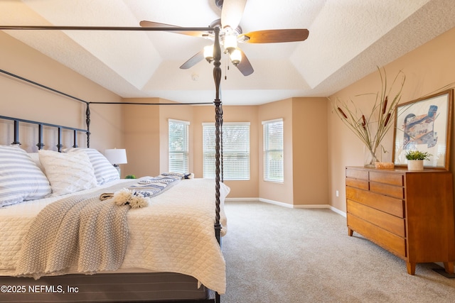 bedroom with light carpet, a textured ceiling, a raised ceiling, and baseboards