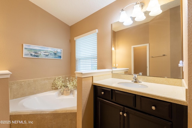 bathroom with a notable chandelier, vanity, lofted ceiling, and a garden tub