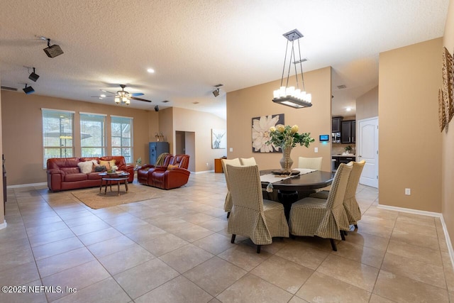 dining space featuring light tile patterned flooring, a ceiling fan, baseboards, and a textured ceiling