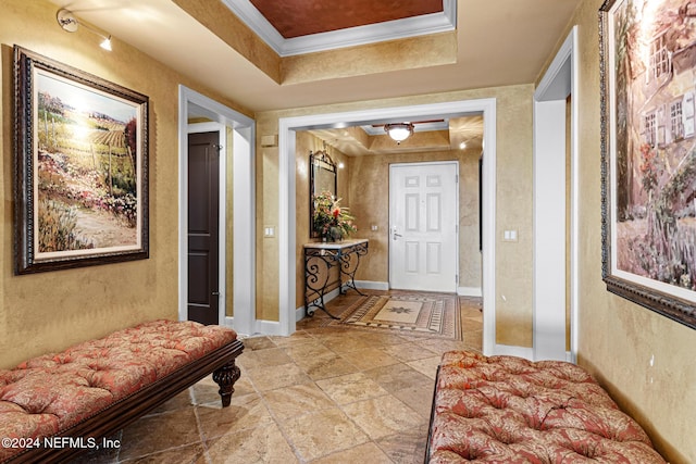 hall featuring a tray ceiling and crown molding