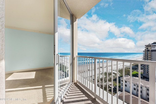 balcony with a water view and a beach view