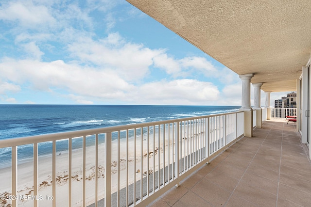 balcony featuring a water view and a view of the beach