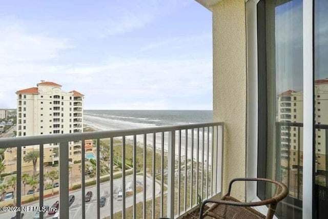 balcony with a water view and a view of the beach