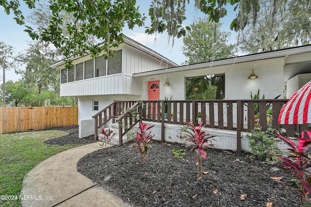 view of front facade featuring a sunroom and a front yard