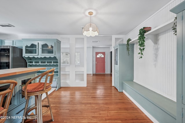 kitchen featuring stainless steel refrigerator, a chandelier, and wood-type flooring