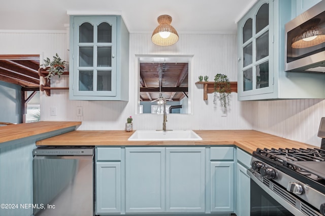 kitchen featuring blue cabinetry, sink, beam ceiling, and appliances with stainless steel finishes