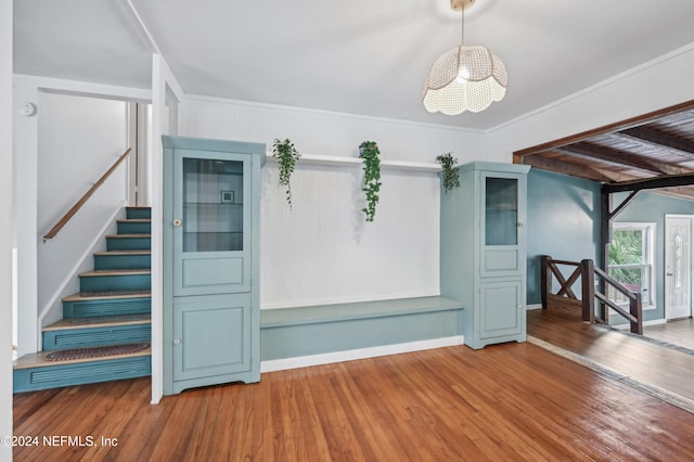 unfurnished living room with crown molding, a chandelier, and hardwood / wood-style flooring