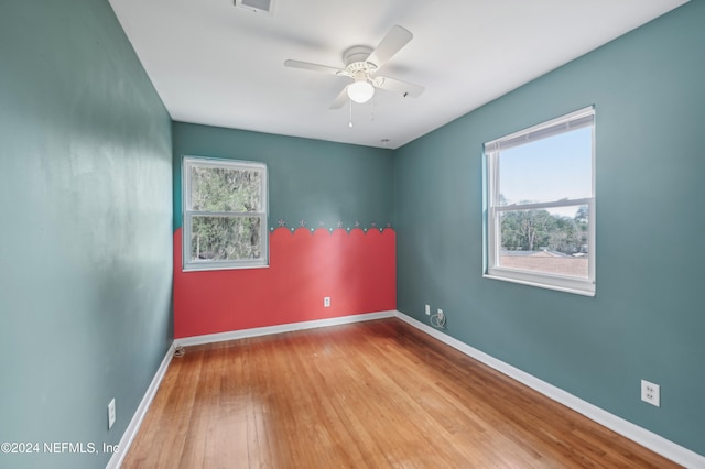 unfurnished room with ceiling fan, a healthy amount of sunlight, and light wood-type flooring