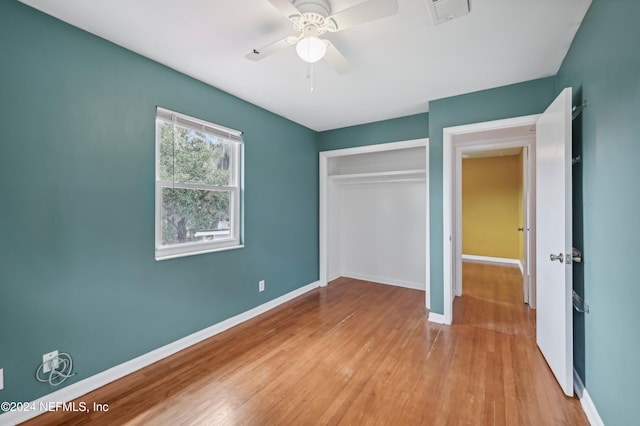 unfurnished bedroom featuring ceiling fan, a closet, and light hardwood / wood-style floors