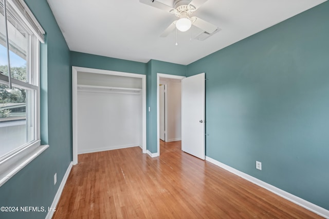 unfurnished bedroom featuring a closet, light hardwood / wood-style floors, and ceiling fan