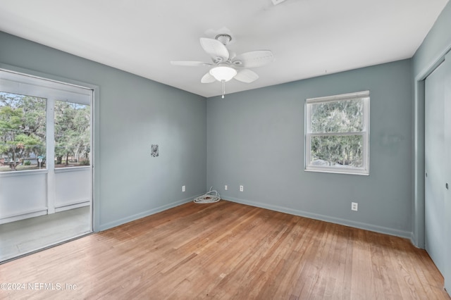 spare room with light hardwood / wood-style flooring, ceiling fan, and a healthy amount of sunlight