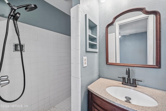 bathroom with vanity and tiled shower