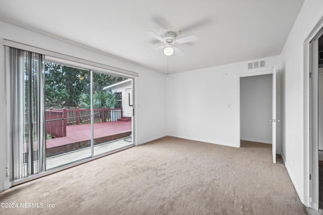 unfurnished room with ceiling fan and carpet