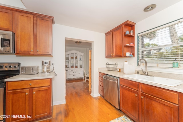 kitchen with sink, light hardwood / wood-style floors, and appliances with stainless steel finishes