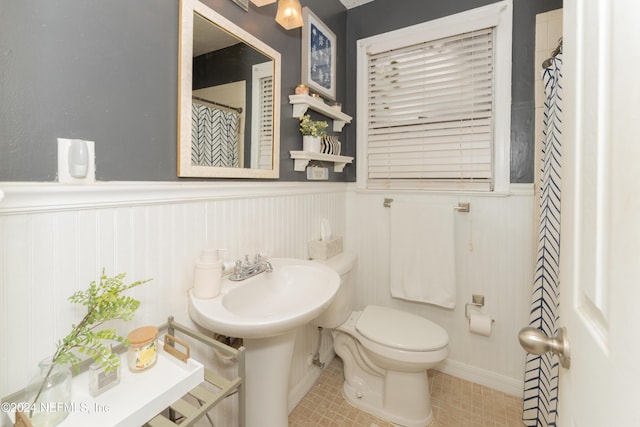 bathroom featuring toilet, tile patterned flooring, and a shower with shower curtain