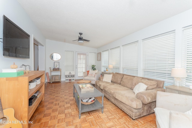 living room featuring a textured ceiling, ceiling fan, and light parquet floors